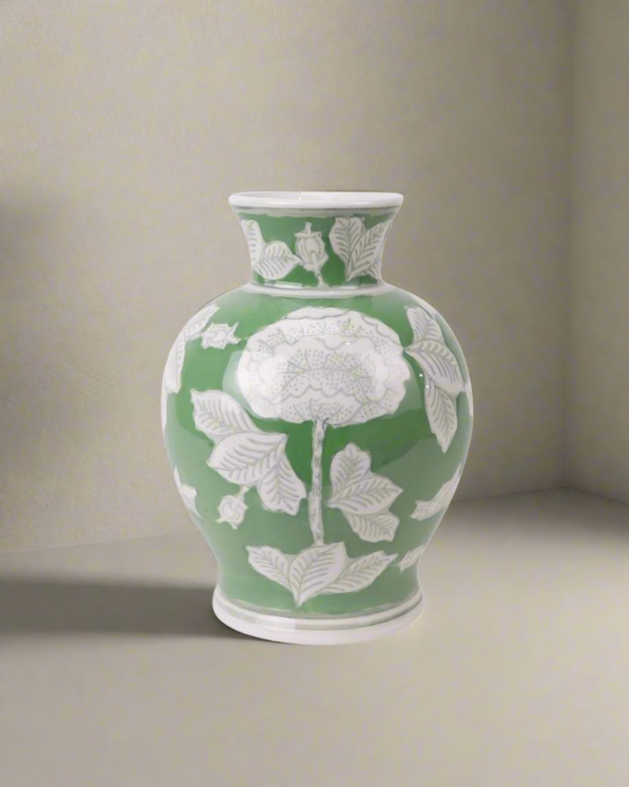 Grønn vase med hvite blomster